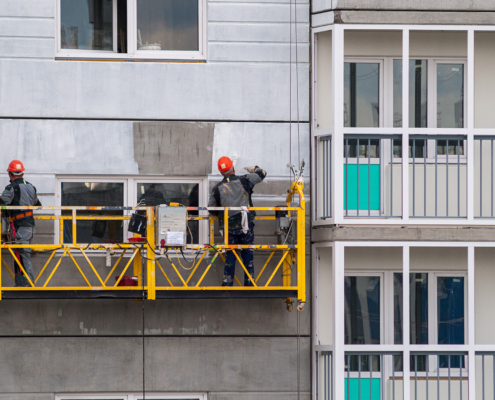 People Painting Exterior Of A Commercial Building