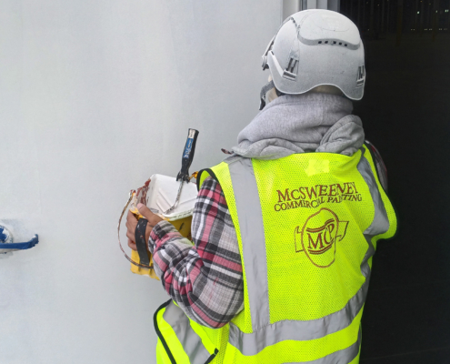 Mcsweeney Worker On Jobsite Painting Door