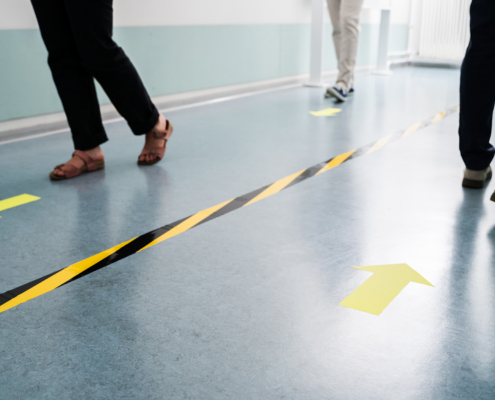 People In Office Following Social Distancing Tape Markings